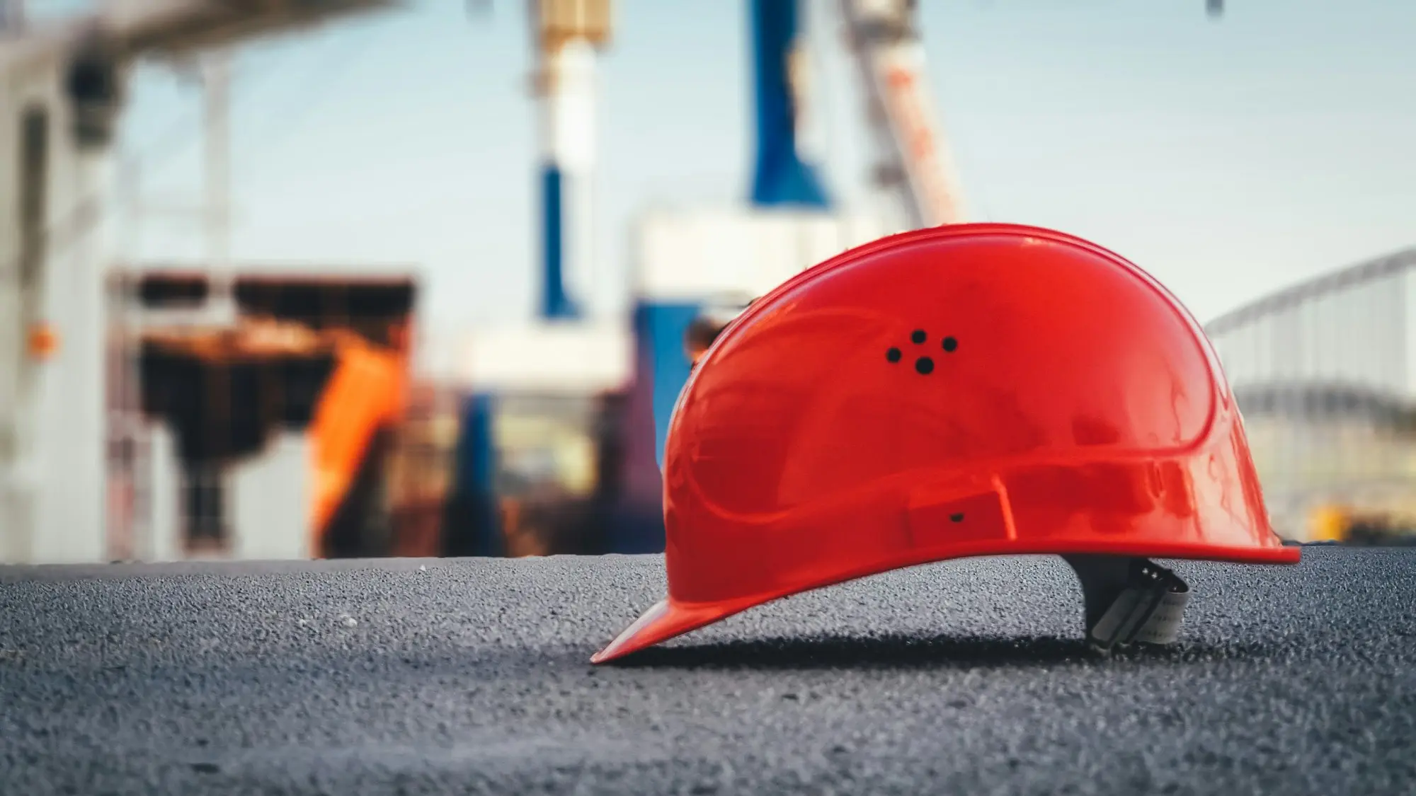Un casque de chantier rouge posé au premier plan, symbolisant la reconstruction et la réinvention de l'équipe de basketball U11M du Stade Clermontois après son titre.