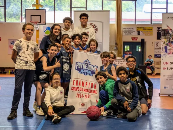 Photo de l'équipe de basketball du Stade Clermontois U11M posant avec la bannière de Champion de la Coupe du Puy de Dôme Masculine 2024-2025 après leur victoire.